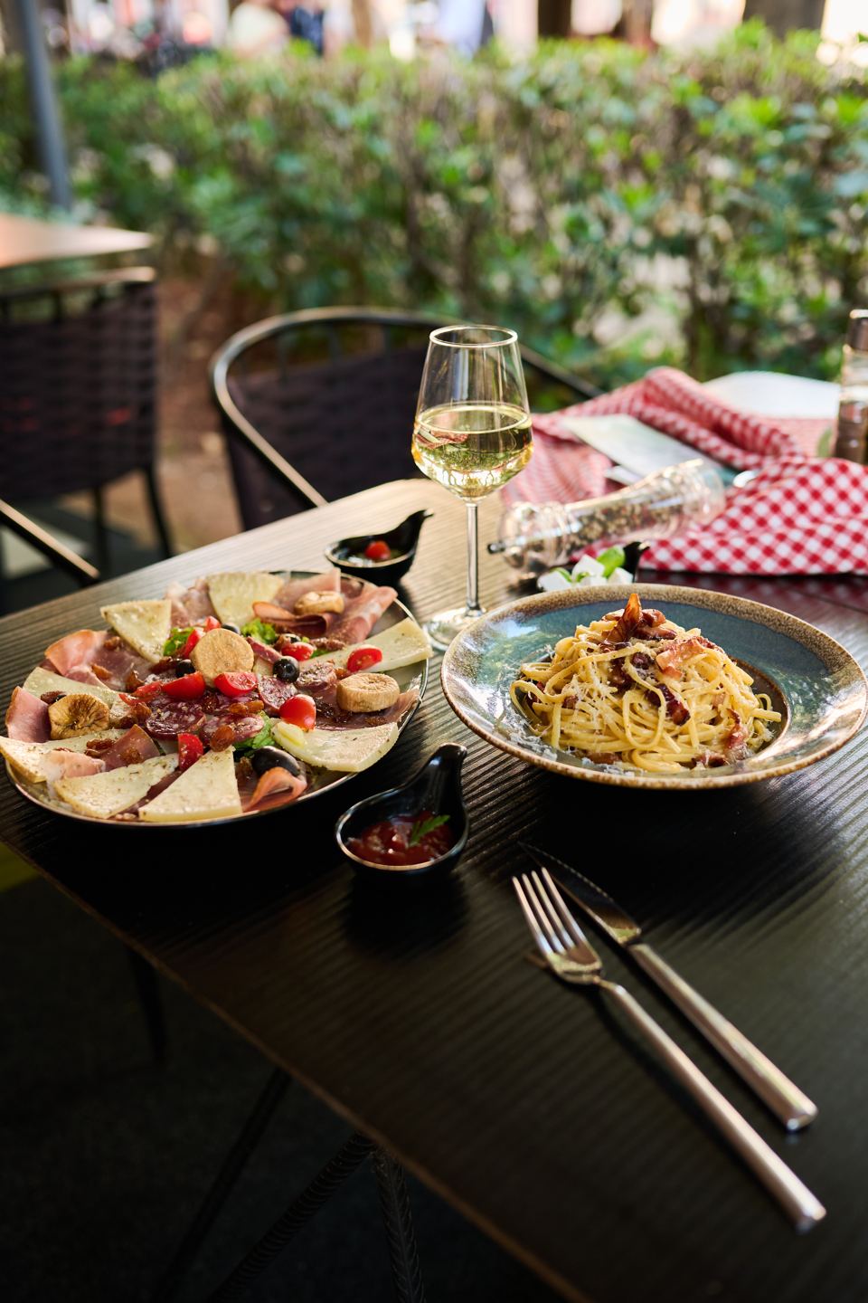 Prosciutto and cheese platter, pasta carbonara and white wine on the terrace